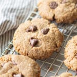 chocolate chip cookies on a wire rack over a striped gray towel