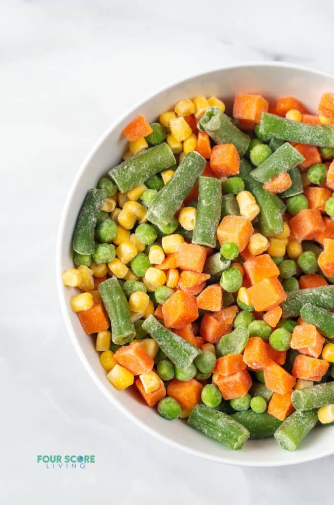frozen mixed vegetables in a white bowl.