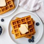top down view of almond flour waffles on a white plate topped with butter