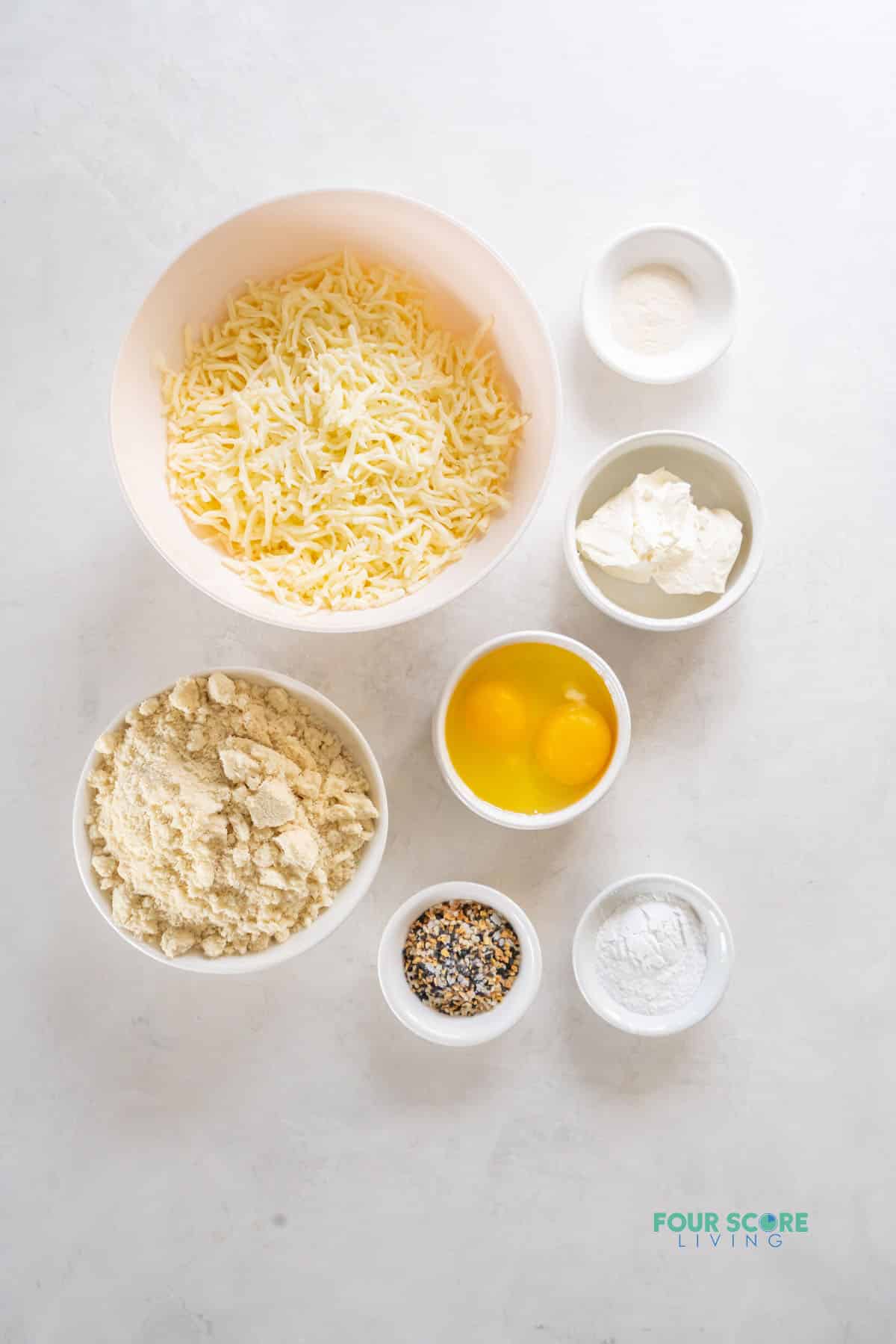 The ingredients needed to make keto bagels, all in separate bowls on a counter, viewed from above
