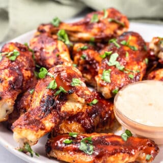 keto chicken wings on a white plate with sauce
