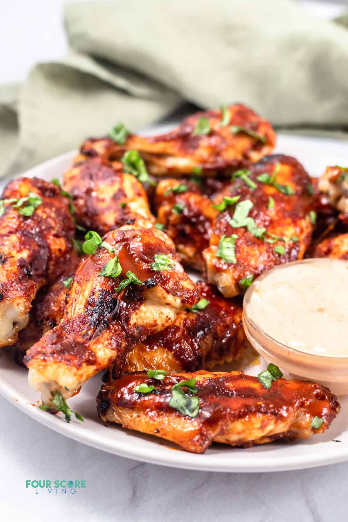 keto chicken wings on a white plate with sauce