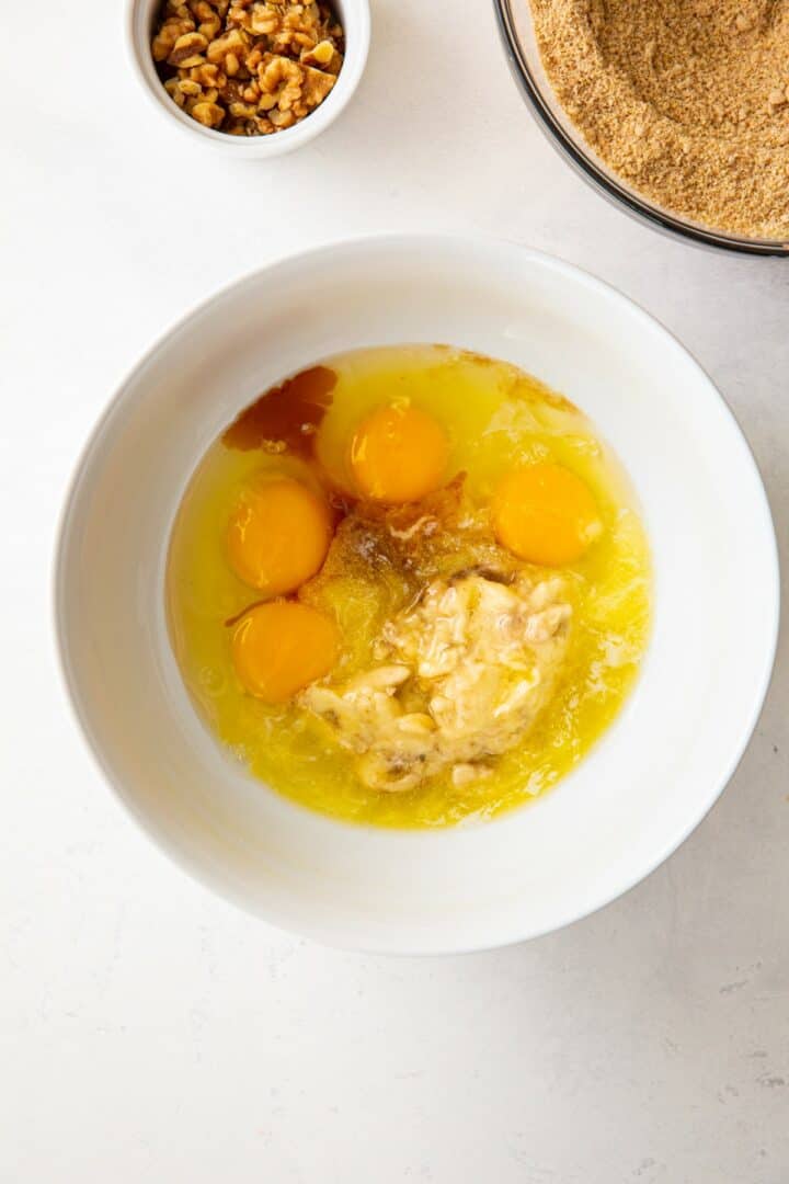 white bowl containing the wet ingredients for making banana bread