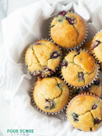 almond flour blueberry muffins in a white bowl with a white tea towel