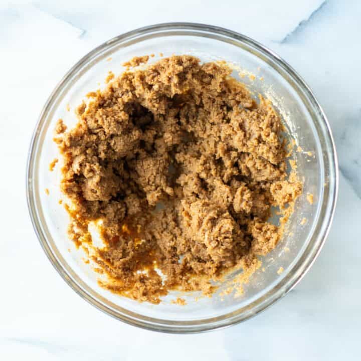 Glass bowl filled with almond butter cookie batter.
