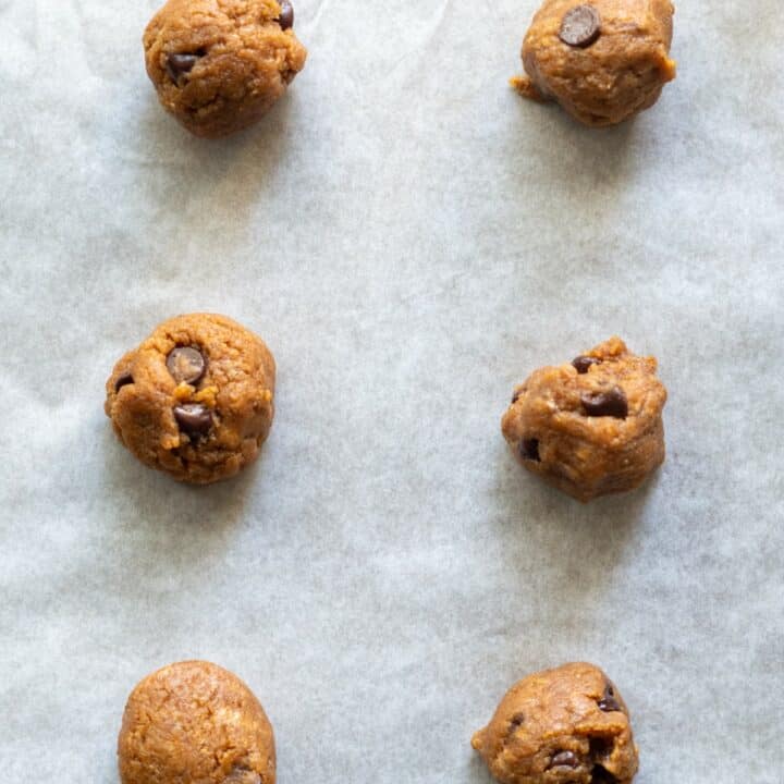 Parchment lined baking sheet with 2 inch cookie dough balls spaced 2 inches apart.