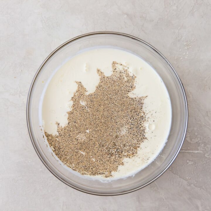 glass bowl containing eggs, whole milk, heavy cream, mustard, salt and black pepper.