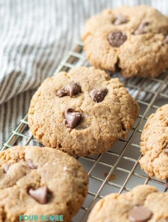 Chocolate chip cookies on a wire rack over a towel