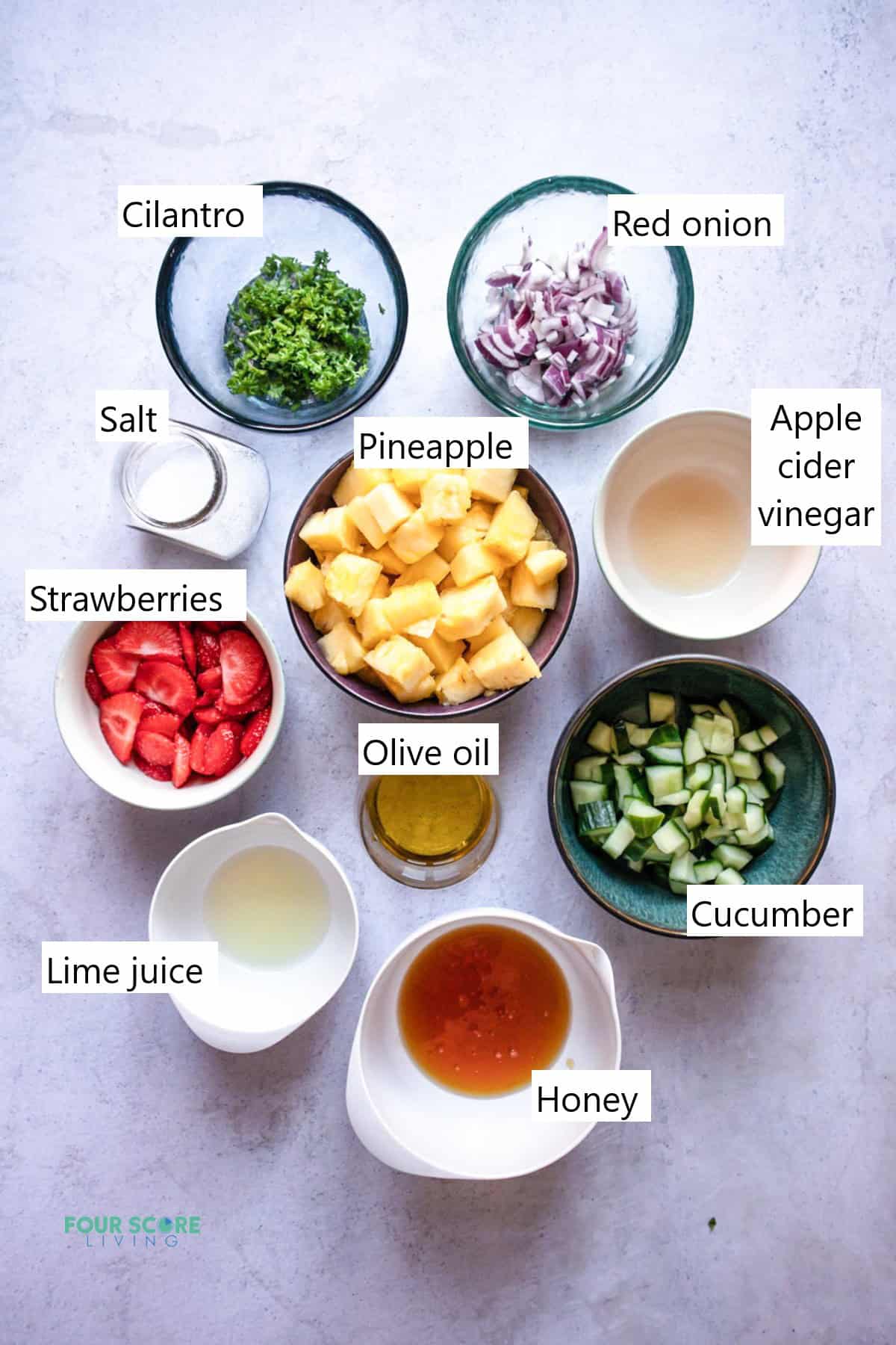 Ingredients needed to make pineapple salad in separate bowls.