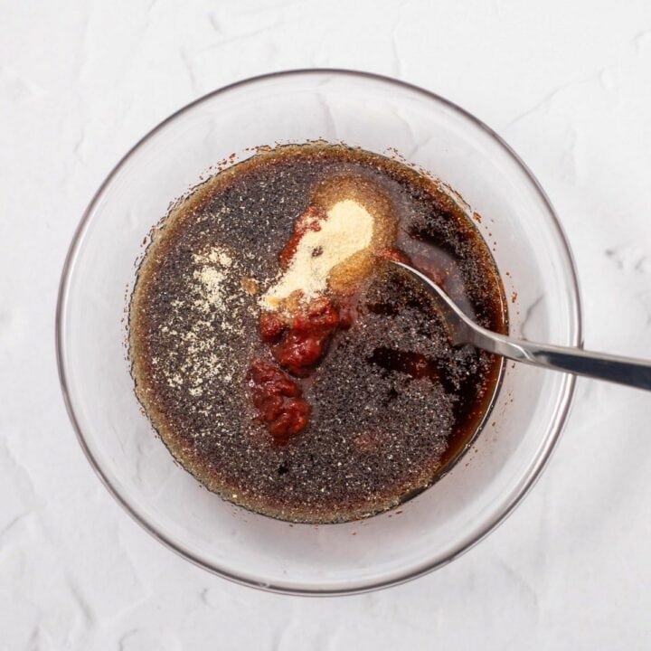 Glass bowl with BBQ sauce ingredients being mixed together.
