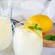 keto lemonade in a glass with lemon and mint with a lemon in the background.