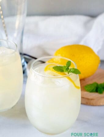 keto lemonade in a glass with lemon and mint with a lemon in the background.