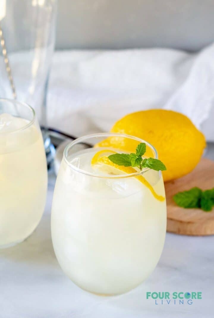 keto lemonade in a glass with lemon and mint with a lemon in the background.